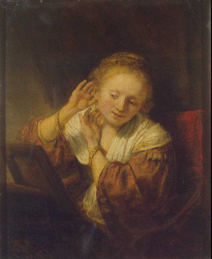 Рембрандт Харменс ван Рейн. Молодая женщина, примеряющая серьги
