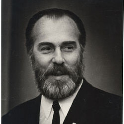 Боковой профиль женщины в коричневой водолазке и белой сумке. Она смотрит с закрытыми глазами.